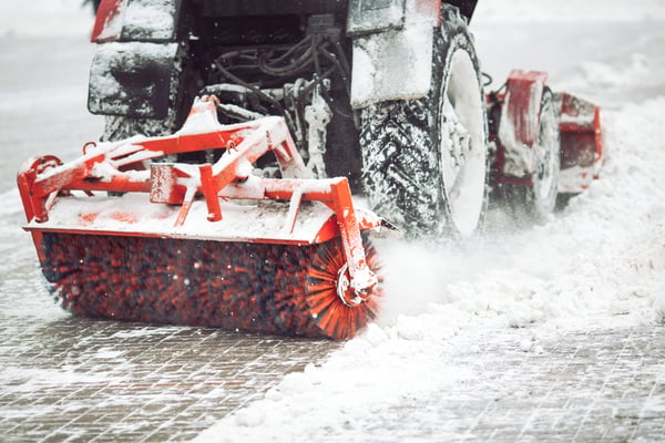 Eine Baumaschine räumt den Schnee auf den Straßen